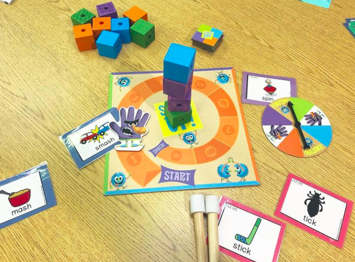 Table set up with minimal pairs (smash-mash, stick-tick, spin-pin) within a game activity